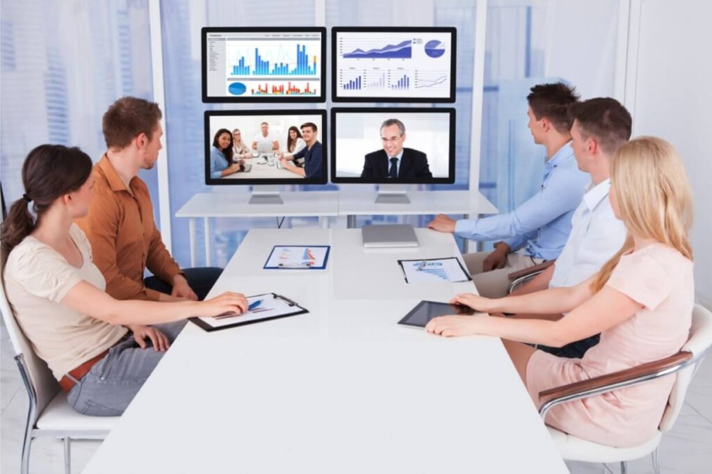 Photo of a team in a meeting room attending a zoom meeting